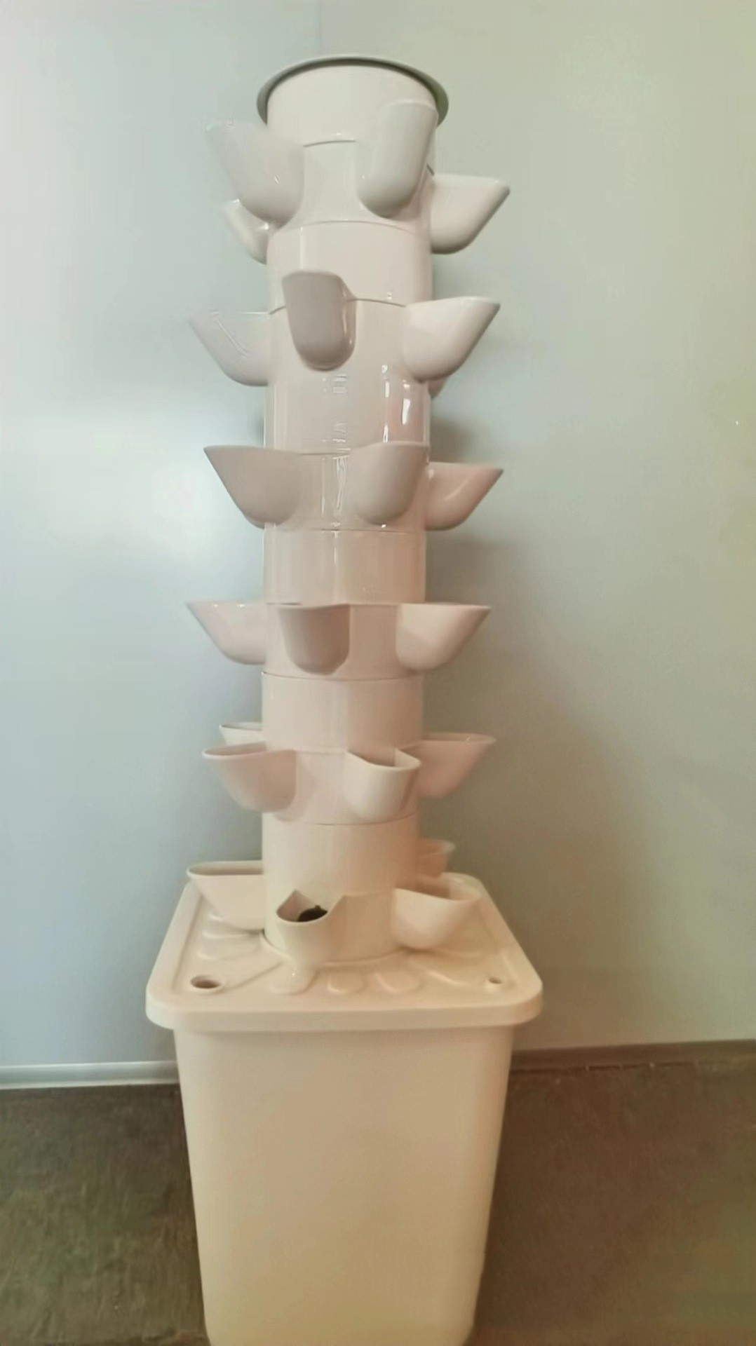 White hydroponic garden tower showing planting pockets and reservoir